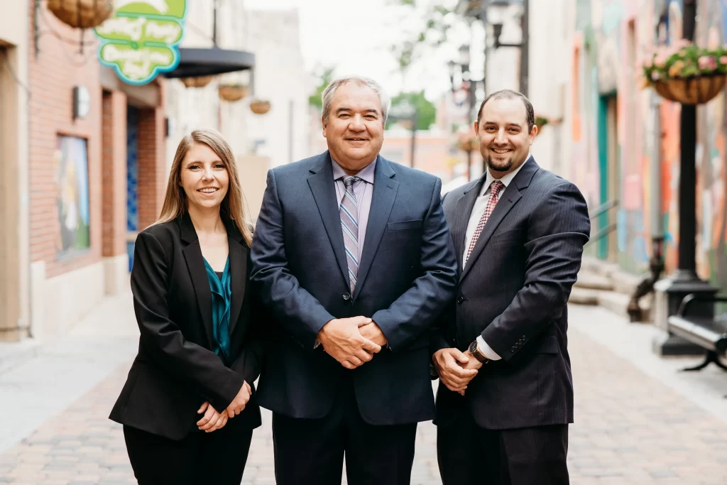 Hoffman attorneys elyse, brad, and ryan posing in old town fort collins colorado