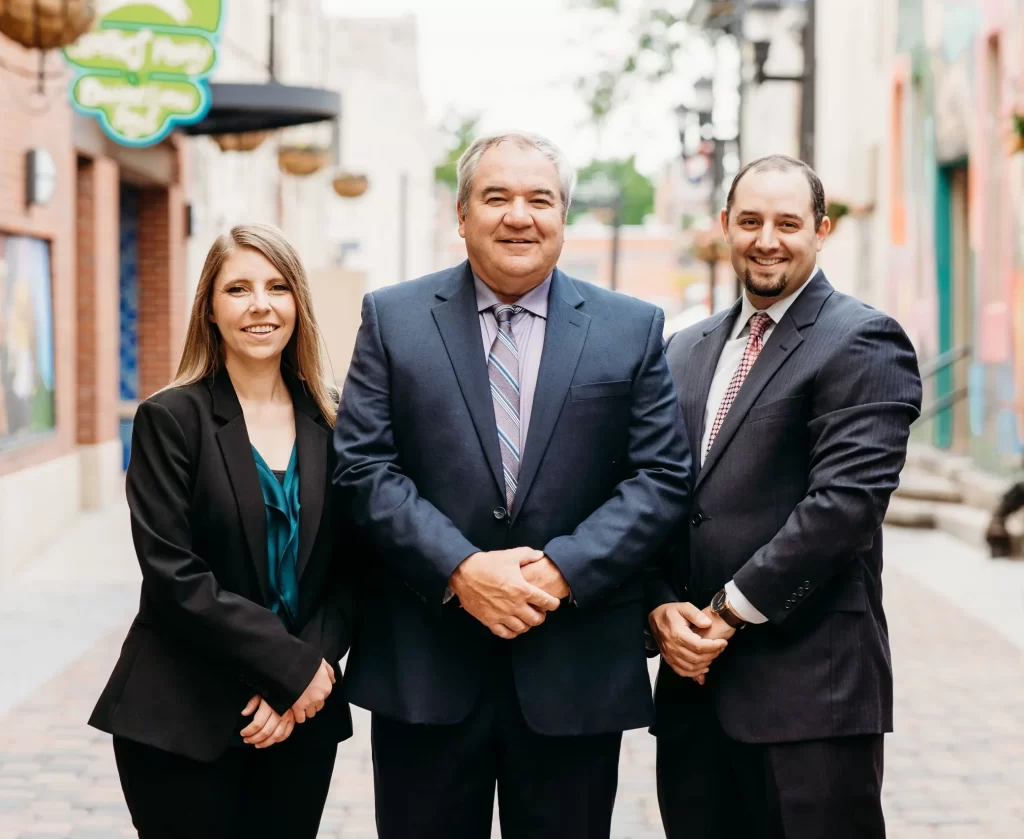 Hoffman attorneys elyse, brad, and ryan posing in old town fort collins colorado