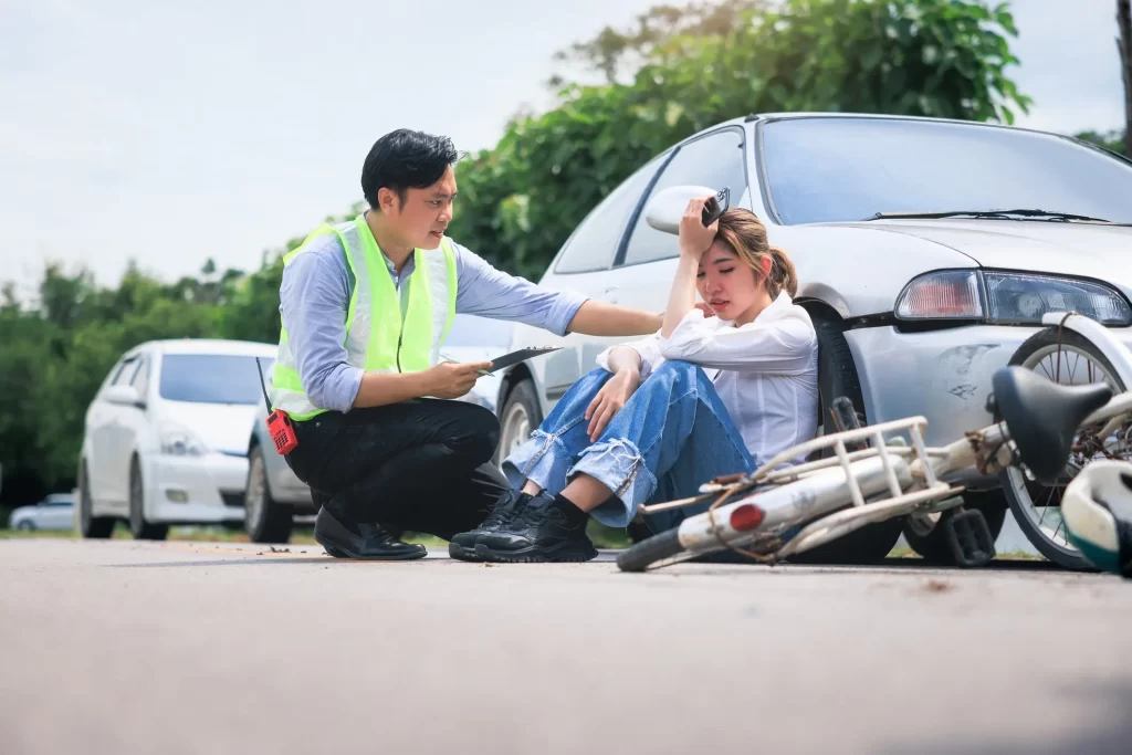 A women being taken cared of by a professional on the side of the road.