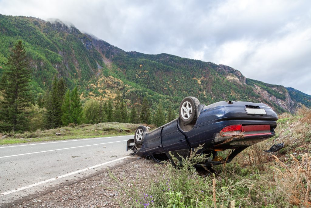 Crushed car accident place on a bend on a mountain road